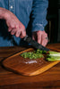 Man chopping vegetables on a Bayali wooden chopping board