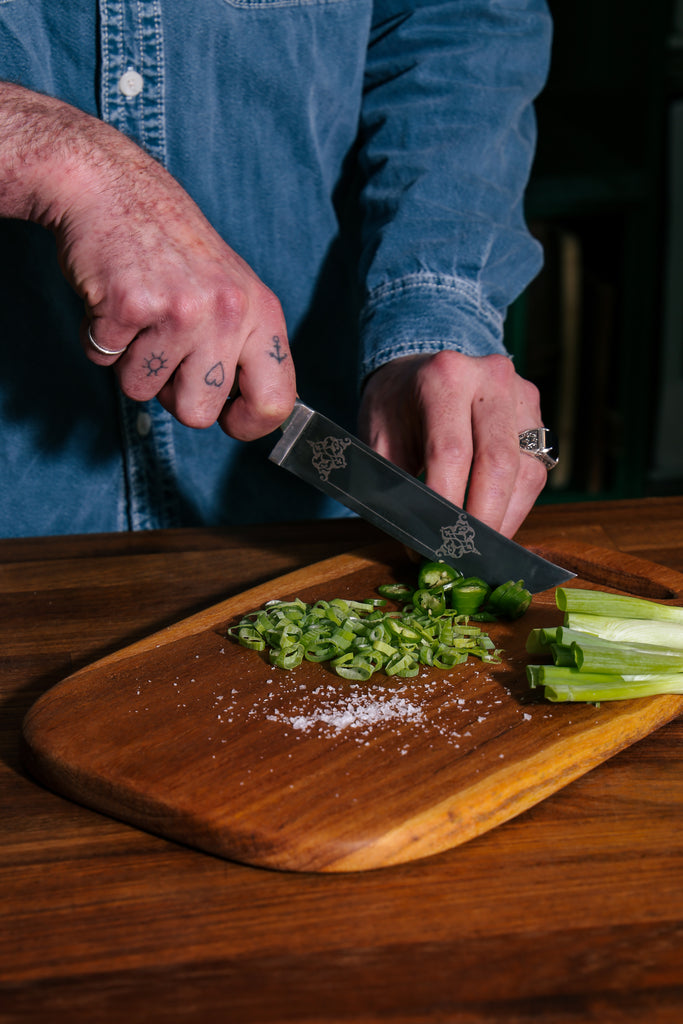 Man chopping vegetables on a Bayali wooden chopping board